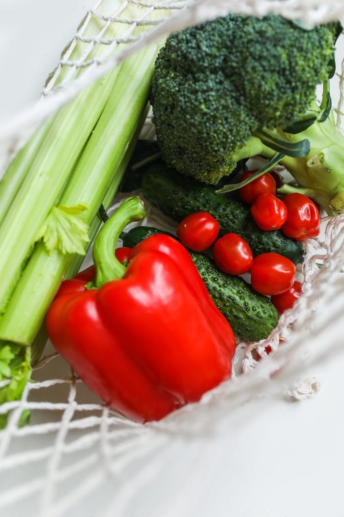 why-choose-us-01 A vibrant mix of fresh vegetables including broccoli, bell peppers, and cucumbers in a net bag.